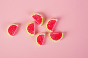 Fruit jelly mixed with sugar on pink background