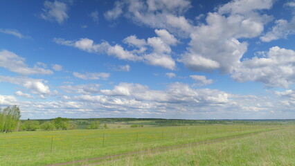 A stunning and captivating panoramic landscape features a bright blue sky and vibrant green fields Time lapse.