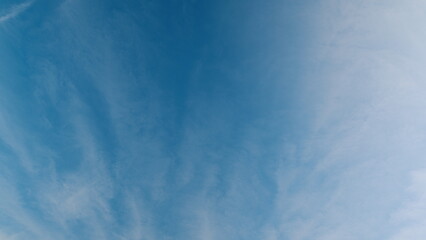 Time lapse. A beautiful and expansive blue sky adorned with wispy clouds floating gracefully above