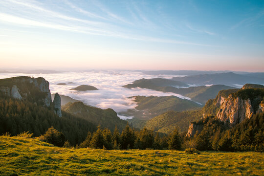 On a mountaintop at sunrise. The mountains are bathed in fog. An atmosphere that delights you. Romanian Carpathian mountains