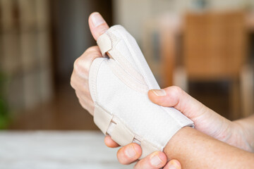 Close-up of a hand wearing an orthopedic brace, providing support and pain relief for conditions...