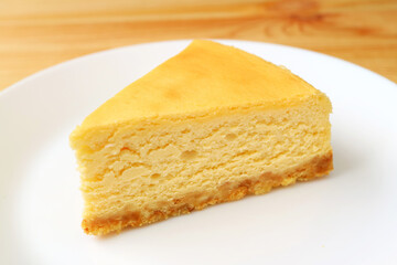 Slice of mouthwatering baked cheesecake on a white plate