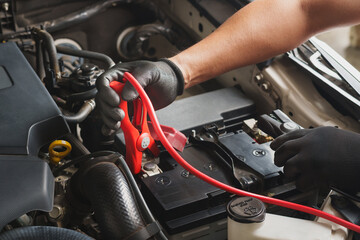 Mechanic Jump Starting Car Battery with Jumper Cables