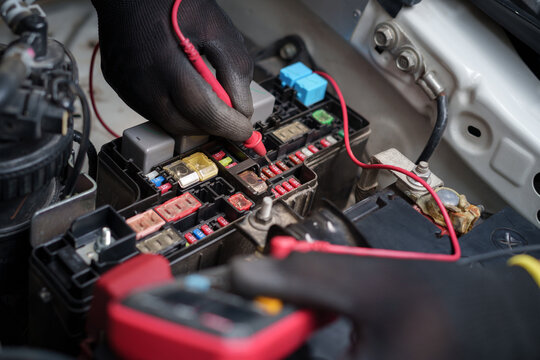 Fototapeta Car Fuse Box Electrical Testing with Multimeter.Technician Checking Automotive Fuses.