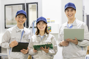 工場でガジェットを使って製品を検査する男女作業員