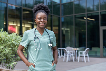 Confident african american female doctor standing in the clinics yard