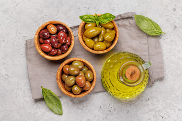 An assortment of various olives presented in a bowl, showcasing different colors, textures, and...