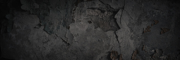 Dark wide panoramic background. Peeling paint on a concrete wall. Dark grunge texture of old cracked flaking paint. Weathered rough painted surface. Patterns of cracks. Darkness background for design.
