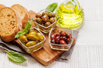 An assortment of various olives presented in a bowl, showcasing different colors, textures, and...
