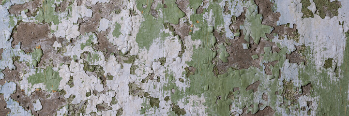 Peeling paint on the wall. Panorama of a concrete wall with old cracked flaking paint. Weathered...