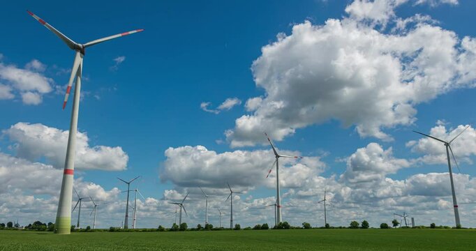 Time-lapse footage of modern wind turbines spinning over vibrant green fields in rural Germany. A powerful symbol of the Energiewende and Germany&rsquo;s response to climate change and energy transition