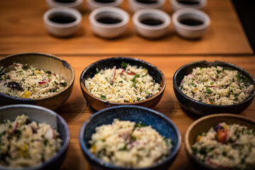 Gourmet Couscous Tasting Setup with Small Sauces on Wooden Table