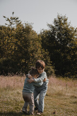 Portrait de deux enfants qui chahutent dans la nature