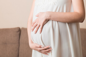 Pregnancy woman in beautiful dress standing on the home