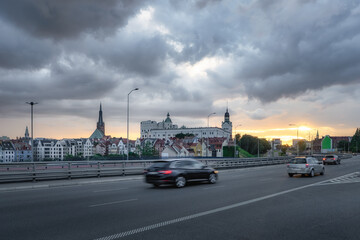 A breathtakingly picturesque city skyline is beautifully illuminated at sunset, showcasing bustling traffic and majestic historic building of Castle of the Pomeranian Dukes, Szczecin, Poland