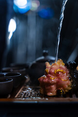 Gongfu tea ceremony with clay cups and a detailed tea tray captured in warm lighting. The Gongfu...