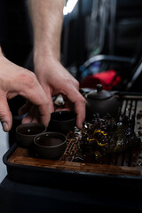 The Gongfu tea ritual features clay teacups, a teapot, and an ornate tea pet. Gongfu tea ceremony...