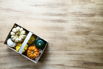 Wicker basket with pumpkin harvest on a wooden antique table. Thanksgiving concept