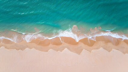 Obraz premium Aerial view of turquoise ocean waves crashing on a sandy beach shoreline