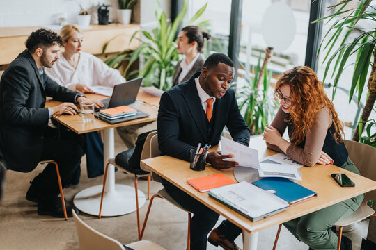 Colleagues discussing work in a relaxing co-working cafe, combining rustic decor with a collaborative atmosphere. The image showcases teamwork, professionalism, and a modern work environment.