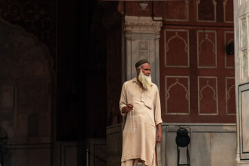 Muslim devotee holding misbaha beads standing in Jama Masjid mosque in Delhi, India