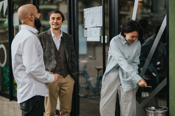 Colleagues enjoy a relaxed conversation during a business meeting in front of a stylish co working...