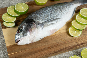 Raw Uncooked Dorado Fish with Fresh Sliced Lime Ready to Cook.