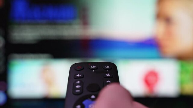 Streaming Service Internet Online Cinema Smart TV. Hand Holding the TV Remote Control Surfing Smart Television and then Turn off Smart TV