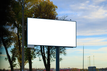 Advertising billboard along the road in the city on a autumn sunny evening. Background for design. 