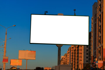 Advertising billboard along the road in the city on a autumn sunny evening. Background for design. 