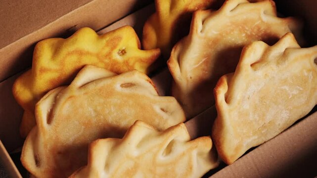 Empanadas in a box with various fillings, concept of pastries and pies. High quality 4k footage