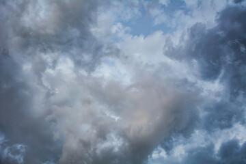 Dark clouds filling the sky with a break of light shining through creating a dramatic and...