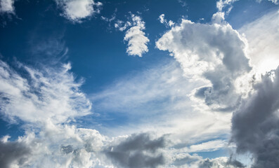 White fluffy clouds scattered across a deep blue sky creating a bright and airy weather background...