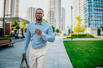 Young black businessman walking confidently in a modern urban environment, showcasing...