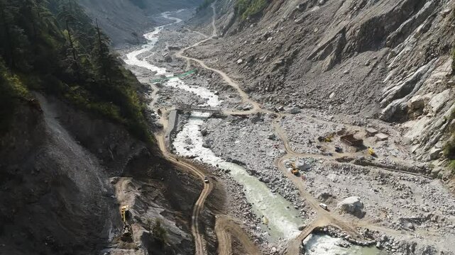 Drone flying over temporary bridges along the dusty paths surrounding teesta river in Lachen.