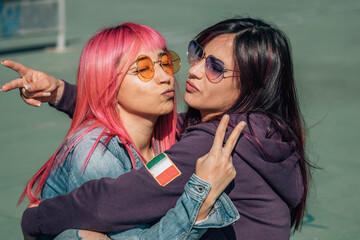 Girls hugging each other with a fun and daring gesture on the street
