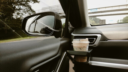 Driving Perspective with Iced Coffee in Car Cupholder and Side Mirror View