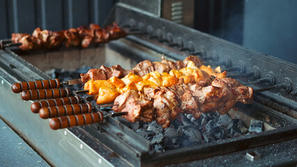 Juicy meat on skewers grilling on automatic barbecue in summer nature
