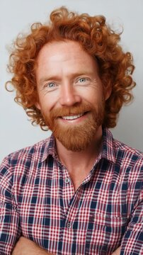Smiling mature caucasian male with curly red hair in plaid shirt