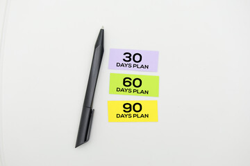 colored paper with words 30 60 90 Days Plan is a strategic outline that encompasses defined goals,...