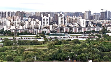 Panoramic view of dense urban housing and high-rise buildings with a backdrop of construction...