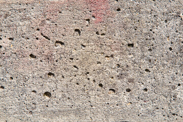 Old concrete wall background with holes left by the evaporation of the mixing water