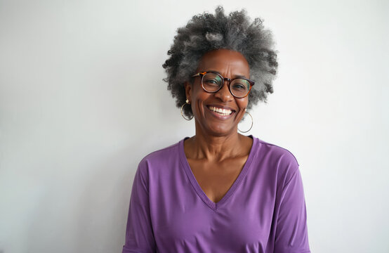 Joyful senior African-American woman with glasses smiling. Portrait of happy, healthy, mature black female on white background. Smiling lady, positive emotions, lifestyle, retirement.