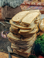 A slice of black bread prepared for sandwiches during a Christmas market