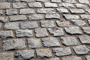 A cobblestone pavement with irregular stone textures, creating a historic and charming surface in old European town, traditional and timeless background