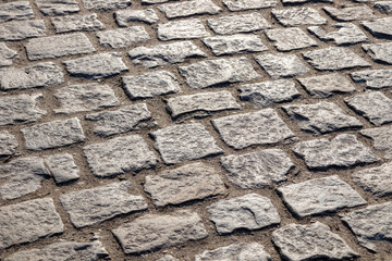 A cobblestone pavement with irregular stone textures, creating a historic and charming surface in old European town, traditional and timeless background