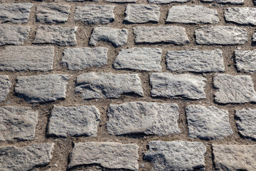 A cobblestone pavement with irregular stone textures, creating a historic and charming surface in old European town, traditional and timeless background
