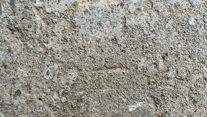 rough concrete wall texture with porous surface, small stone grains, and weathered gray tones ideal for background, graphic design, poster, or branding element


