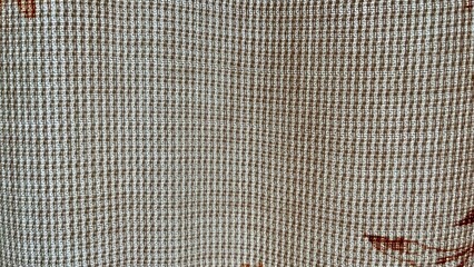 close-up of beige woven fabric with small grid texture and subtle red thread accents, ideal for...