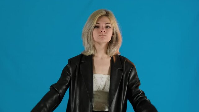 Wicked blonde lady vigorously waves arms silently conveying frustration. Young woman pokes fist in face of offender pursing lips slow motion